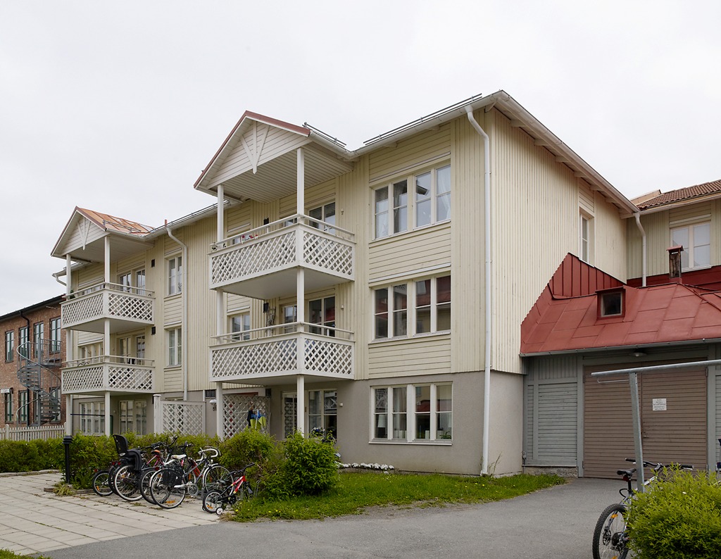 Vit träbyggnad i 3 våningar med balkonger.