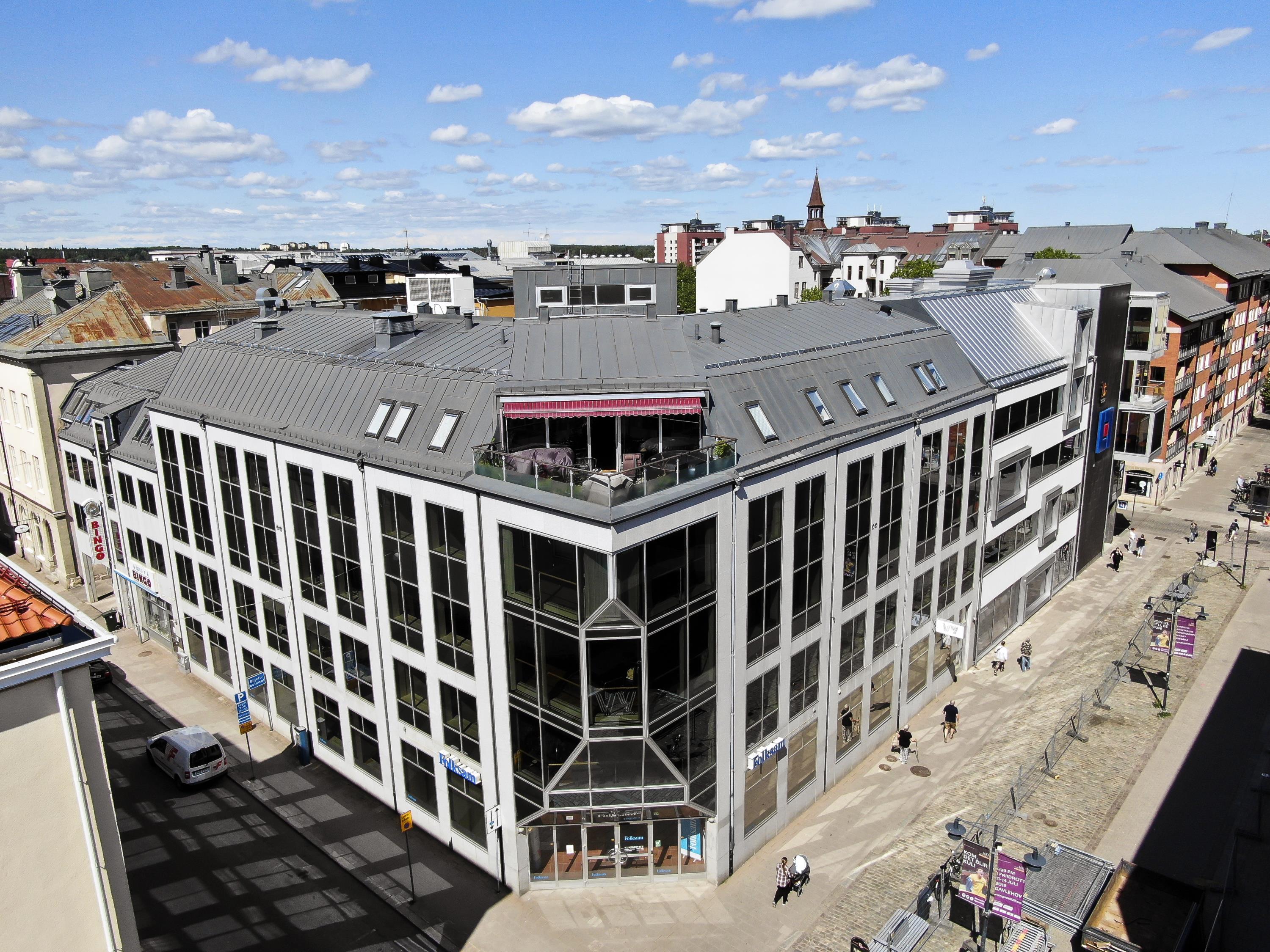 Drönarvy över vit fastighet  med många fönster.