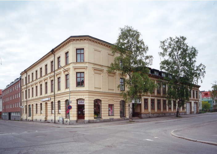 Gul stenbyggnad i 3 våningar.