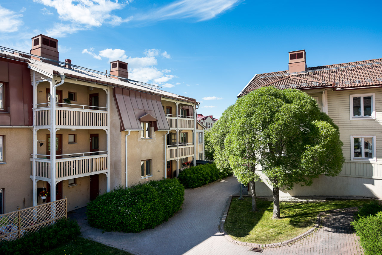 Gul byggnad i 3 våningar med balkonger mot innergård