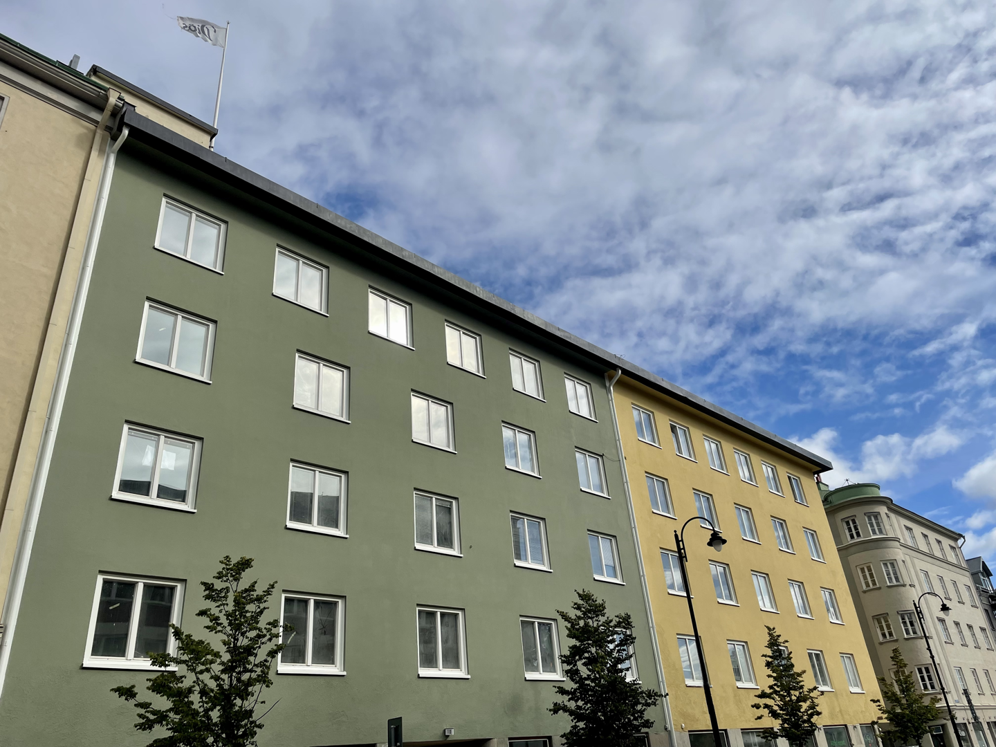 Två sammansatta byggnader i 5 våningar, den ena frön och den andra gul. 