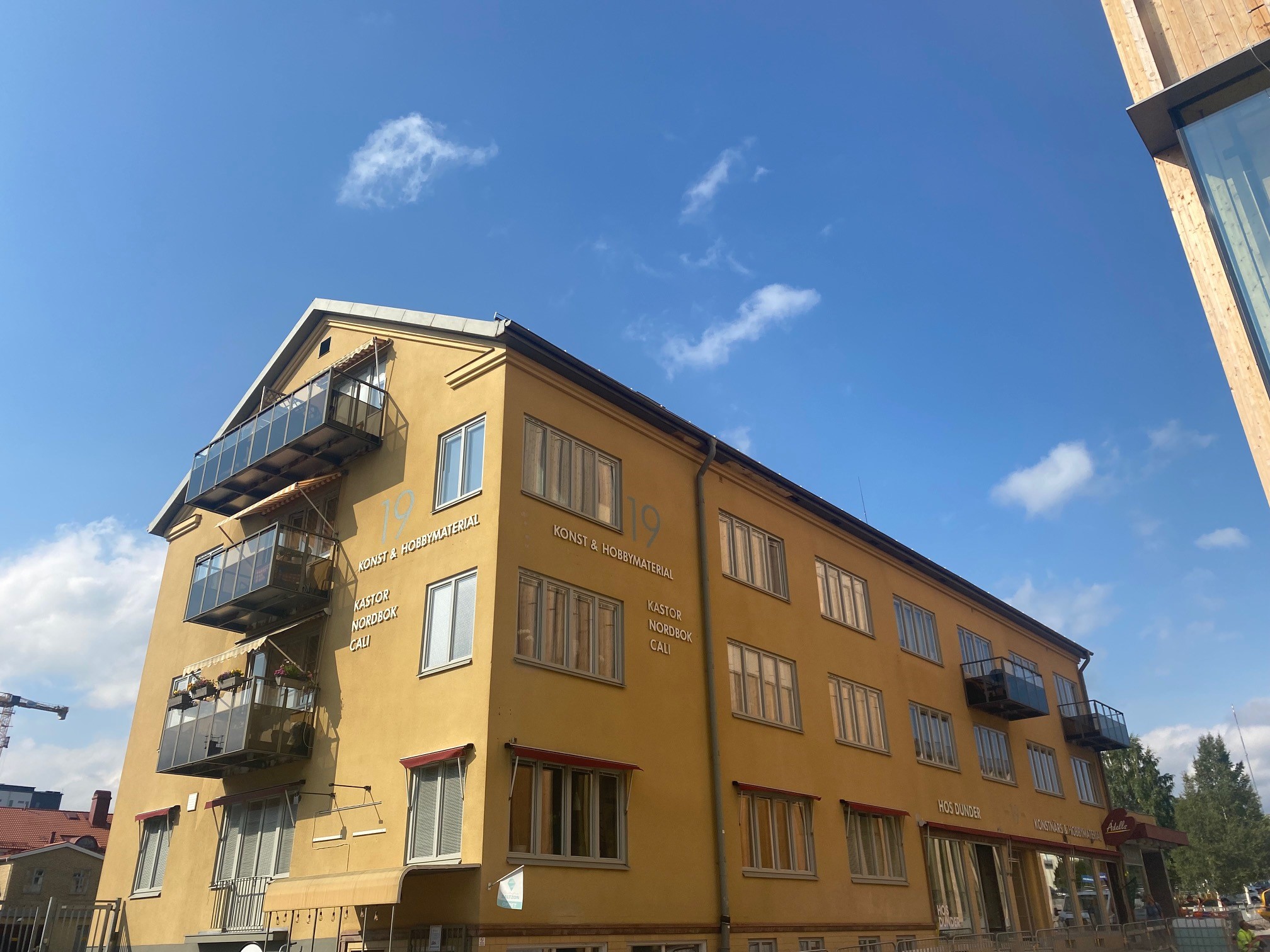 Gul byggnad i 4 våningar med balkonger. 