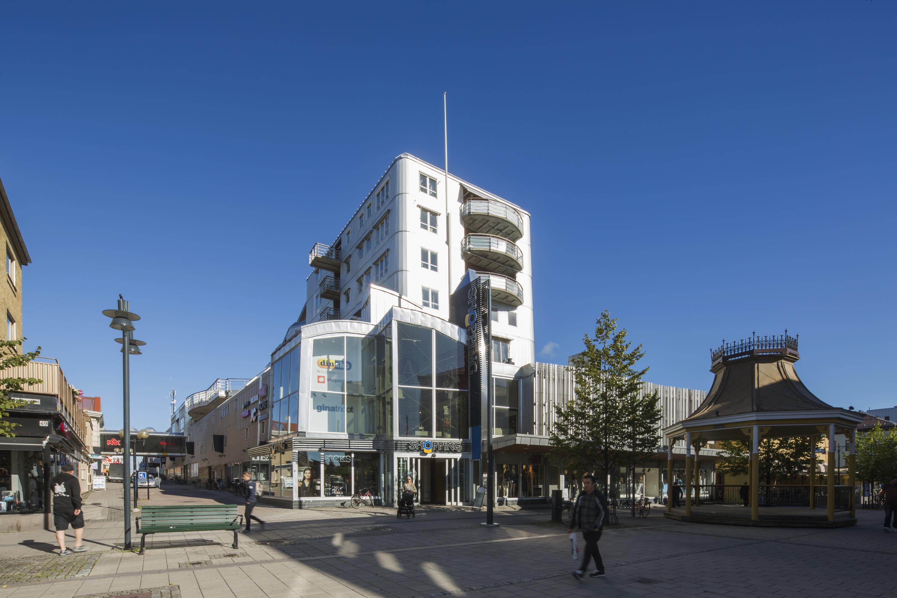 Galleriabyggnad med en tillhörande högre byggnad med lägenheter i.