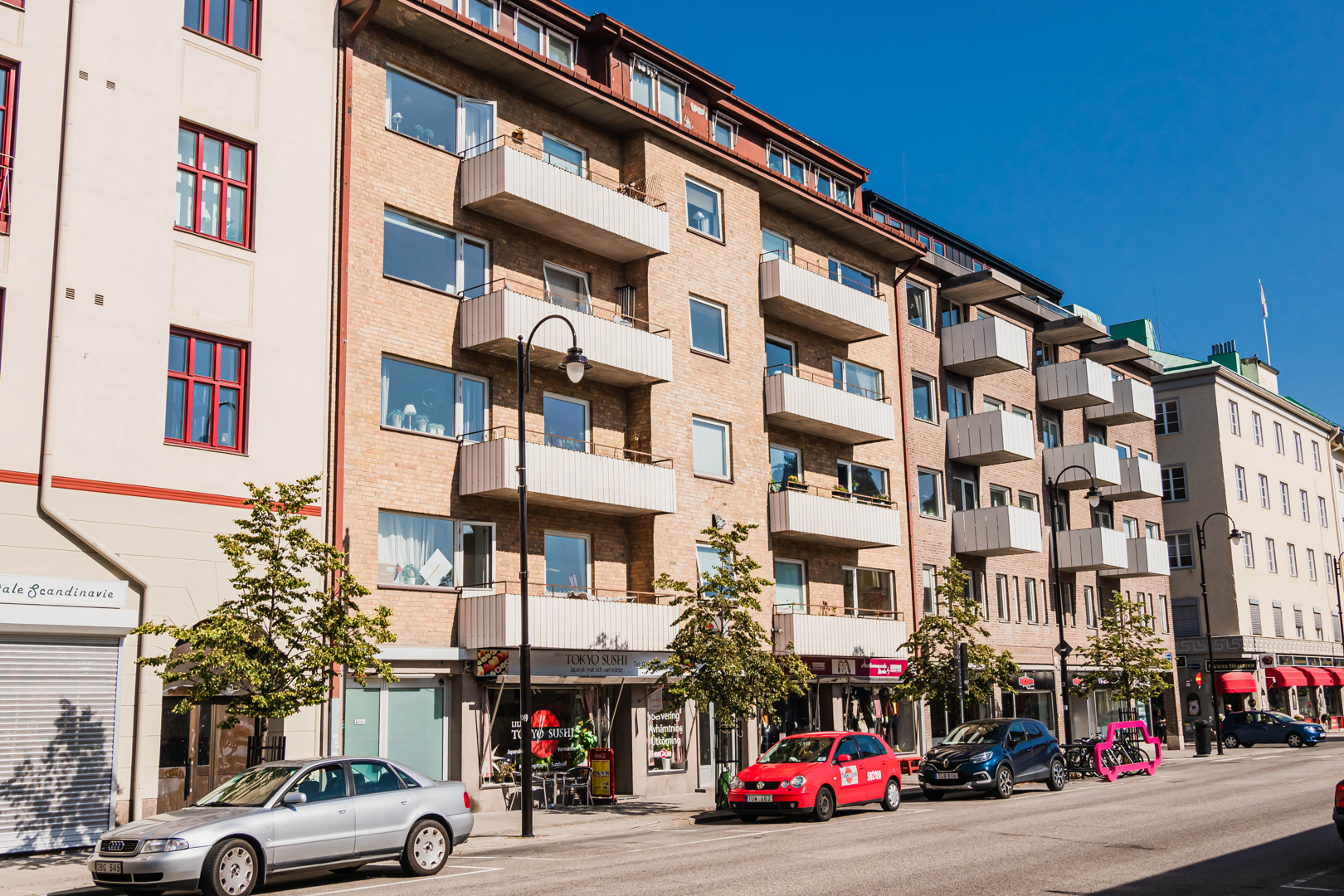 Gul fastighet i 6 våningar med balkonger.
