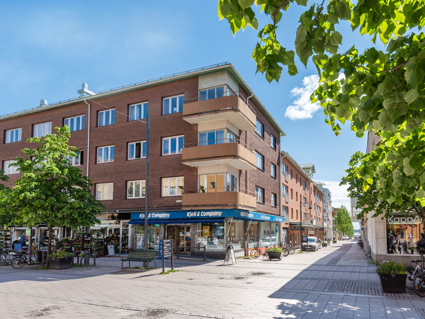 Brun byggnad i 4 våningar med balkonger på hörnet.