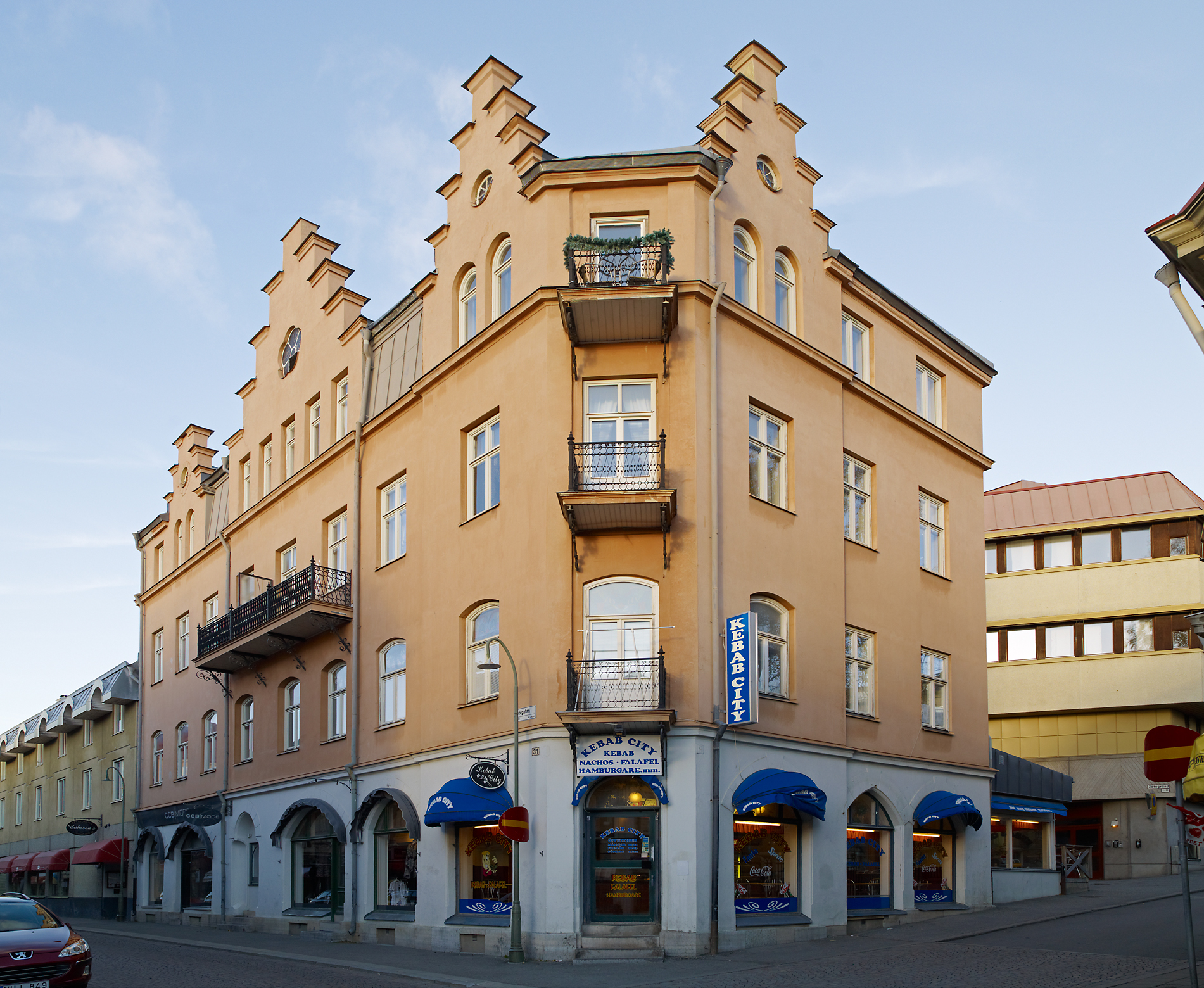 4-våningshus med balkonger. Restauranger i bottenplan.