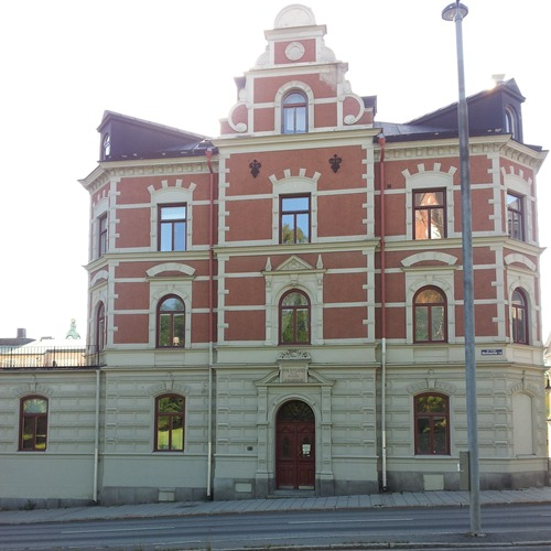 Stenbyggnad i 4 våningar med fina detaljer kring fönstren.